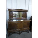 An early 20th Century oak barleytwist mirrorback sideboard with inlaid marquetry panels