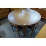 A teak circular extending dining table and four chairs