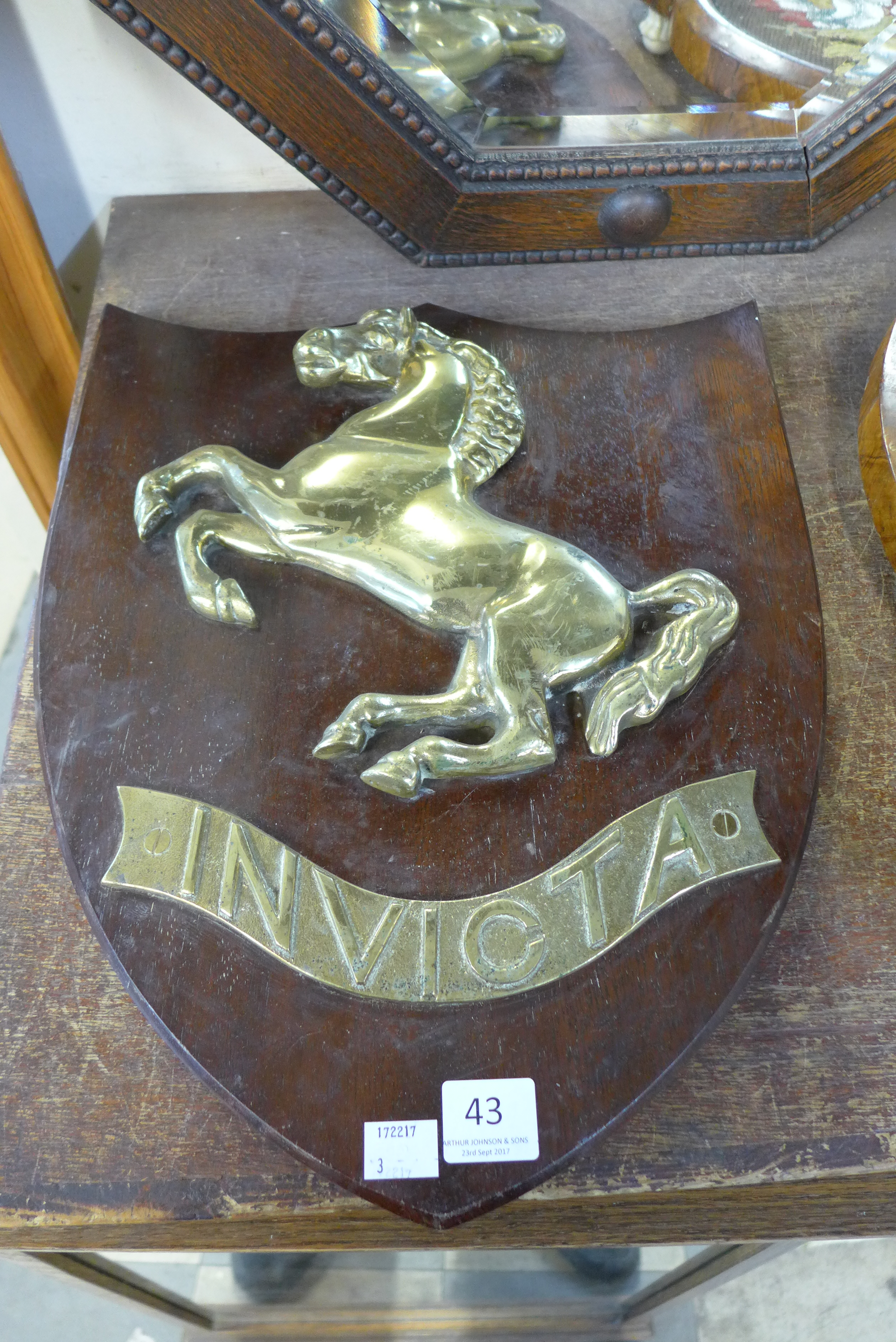 A brass Invicta plaque
