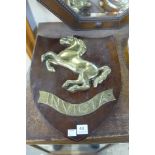A brass Invicta plaque