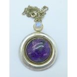 A silver Arts and Crafts style pendant and chain with crystal and purple cabochon