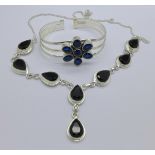 A silver and blue stone bangle and a silver and black stone necklace