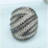 A silver, black and white stone set ring,
