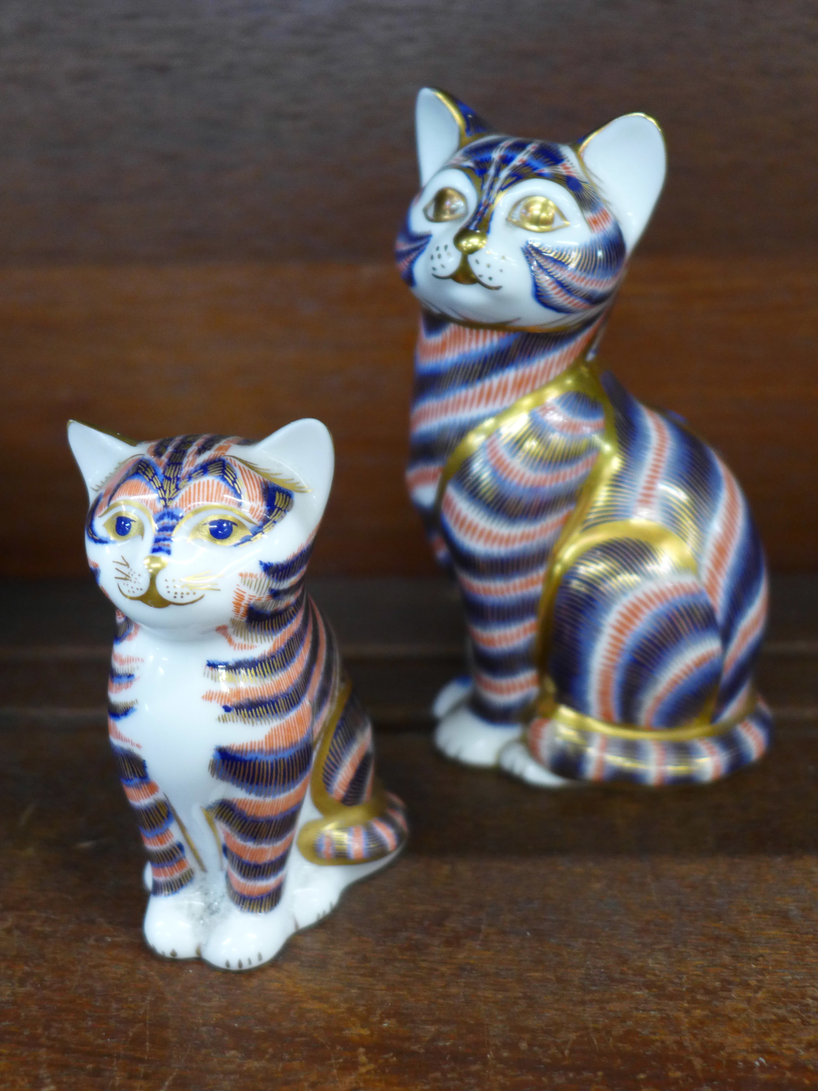 Two Royal Crown Derby cat paperweights, small with gold stopper,