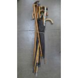 A silver mounted umbrella and a collection of walking sticks,