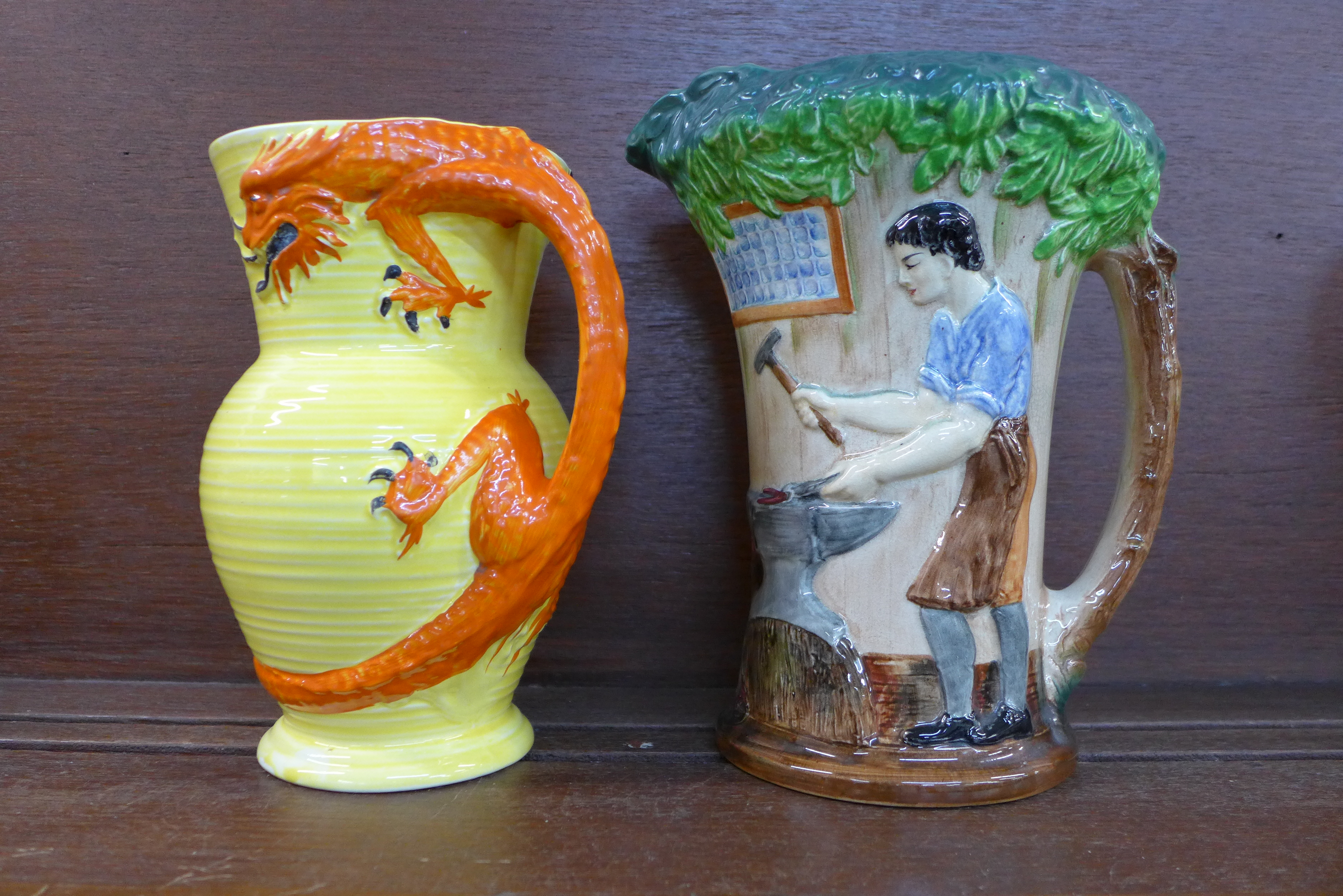 A Burleigh Ware dragon jug and a The Village Blacksmith jug, 19.5cm and 22.