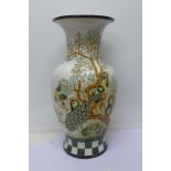 A tall vase decorated with peacocks