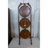 An Edward VII inlaid mahogany folding cake stand