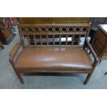 An Arts and Crafts oak and brown leather settee