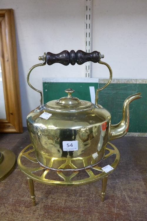 A brass and copper kettle with stand