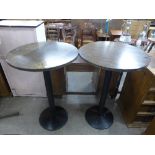 A pair of cast metal based pub tables