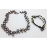 A black freshwater pearl necklace and a freshwater pearl and leather bracelet
