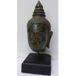 A bronze Buddha head on stand