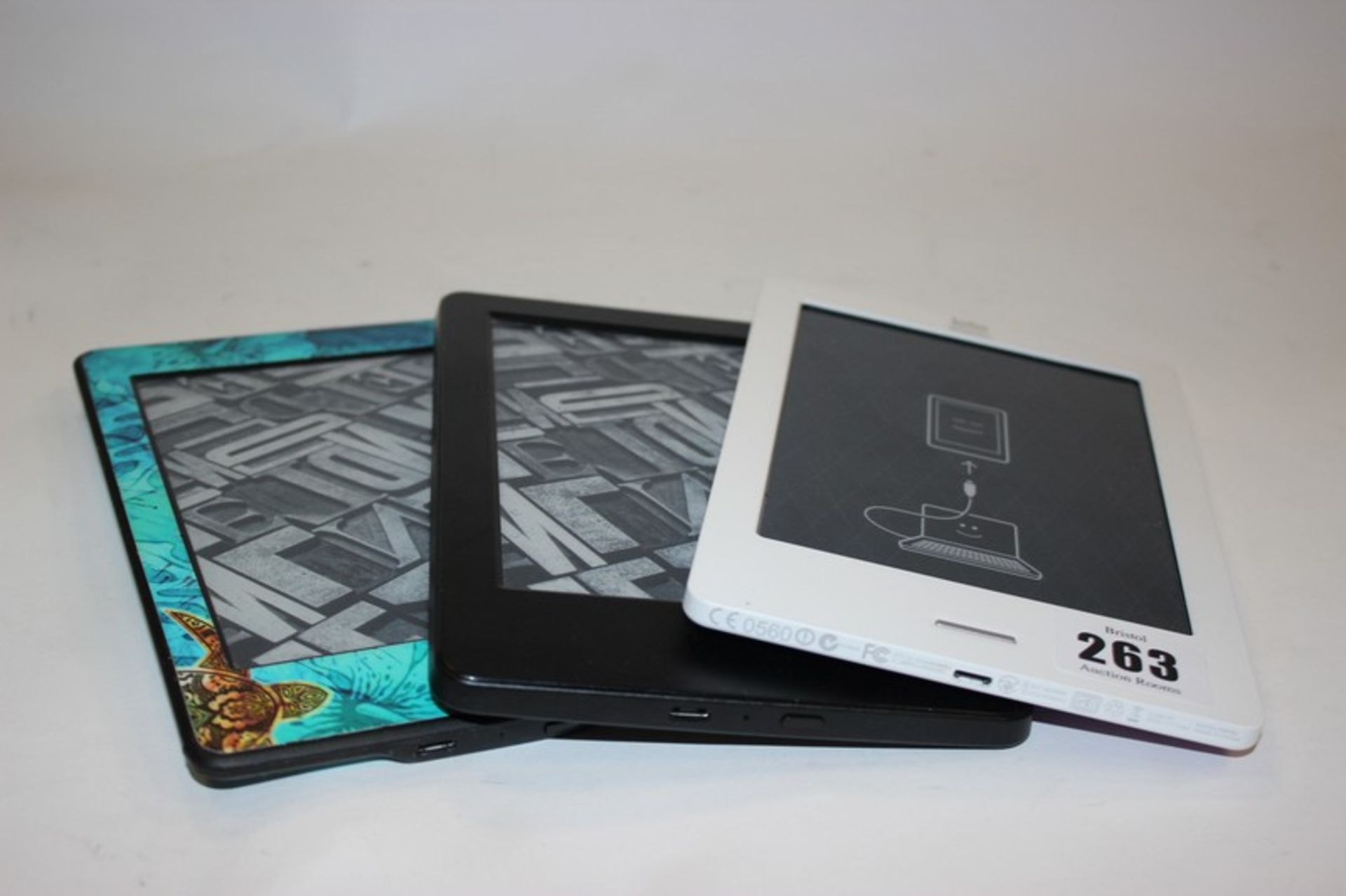 An Amazon Kindle Paperwhite, Amazon Kindle Basic (2014) and a Kobo.