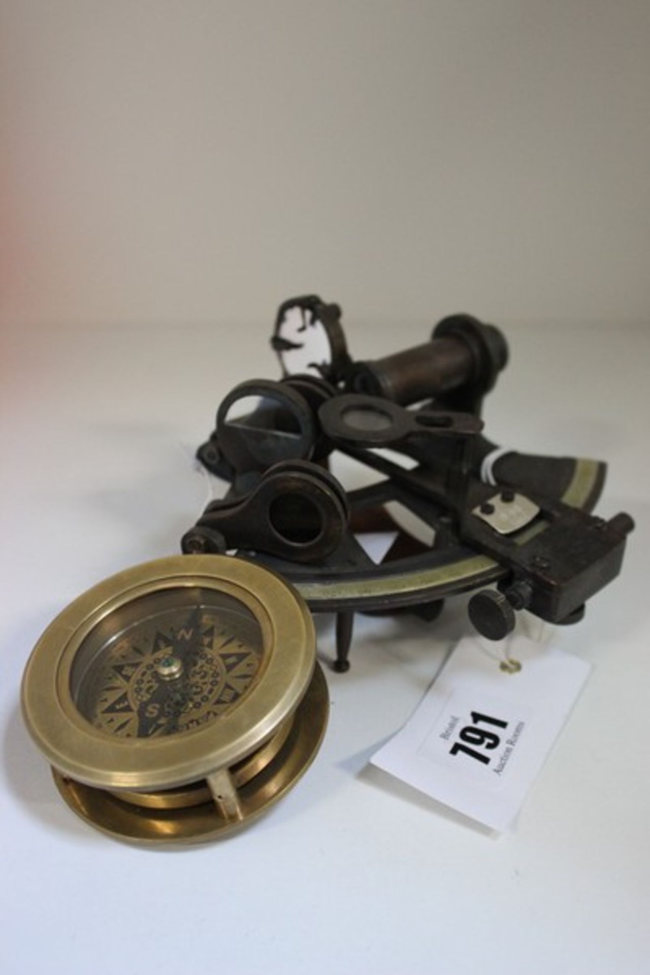 A small sextant together with a compass with magnifying glass.