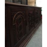 A substantial continental mahogany sideboard comprising four drawers heavily carved and highlighted