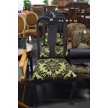 A set of four black painted high back dining chairs with vase shaped splats upholstered in line and