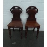 A pair of Victorian mahogany hall chairs with pierced back and turned legs