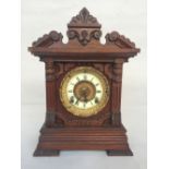 A wooden carved cased mantel clock, movement by Ansonia Clock Co, New York, USA patented June 18.