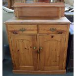 A pine dresser/cupboard with plate stand over two short drawers over a cupboard with double doors