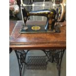 A vintage Singer treadle sewing machine with 2 side drawers and one pull down drawer on a cast iron
