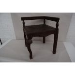 A wooden corner chair with carved acanthus on the seat and a front cabriole leg,