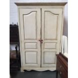 A cream painted wardrobe with two panel doors over bracket feet 56x126x200cm