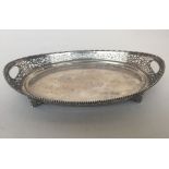 An oval shaped salver on four feet the sides decorated with pierced scrolling foliage and beaded