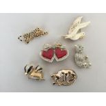 Six yellow metal brooches to include a double heart, a dove, a teddy bear, a jaguar,