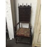 A carved high back chair, top rail decorated with spindle and carved half circles,
