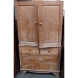 A wardrobe on bracket feet with two panel doors over four drawers,