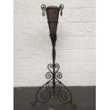 An antique wrought iron Baroque style jardiniere stand with copper cone shaped bowl with incised