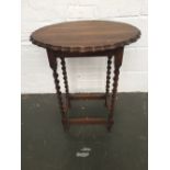 A small side wooden table on barley twisted leg with cartouche shaped top