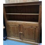 A pine dresser/cabinet with carved pediment on two shelves over cupboard with double doors 125cmW