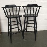 A pair of black wooden high chairs with turned spindles back and legs