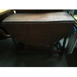 An oval gate leg table with end drawer and turned legs