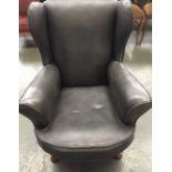 A Parker Knoll style wing back armchair in grey leather