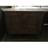 A sideboard comprising two double doors with foliate carving and shelf below 120 x 36 x 80cmH