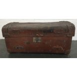 A vintage leather travelling trunk with leather handles bearing various labels such as Red Star