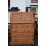 A pine bureau with inner shelves above two short drawers over three long,