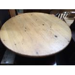 A large round pine kitchen table on baluster support and tripod legs 136cmW