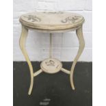 A white painted round side table with stencil foliate design over cabriole legs with undershelf