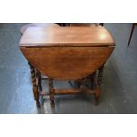 A small oval gate leg table with barley twist legs 74cmH