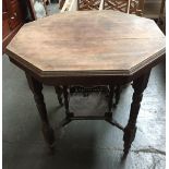 Octagonal table with turned legs on castors, stretcher and gallery tray to underside,