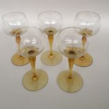 Five wine glasses with flower shaped yellow colour stems