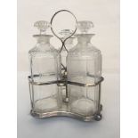A silver plated three bottle decanter stand on three ball feet with decanters,