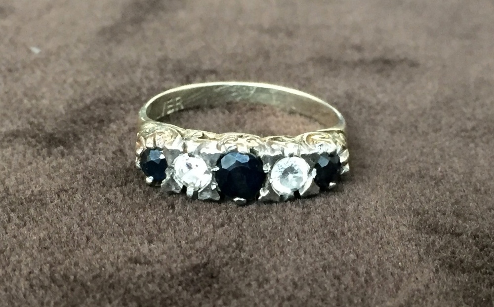 A yellow metal ring with three sapphires and two zirconia