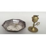 A brass chamberstick with a silver plated octagonal bowl on three ball feet