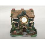 A Wm Widdop quartz mantel clock in the form of a house,