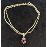 A 9ct gold chain with red stone pendant in 9ct gold setting,